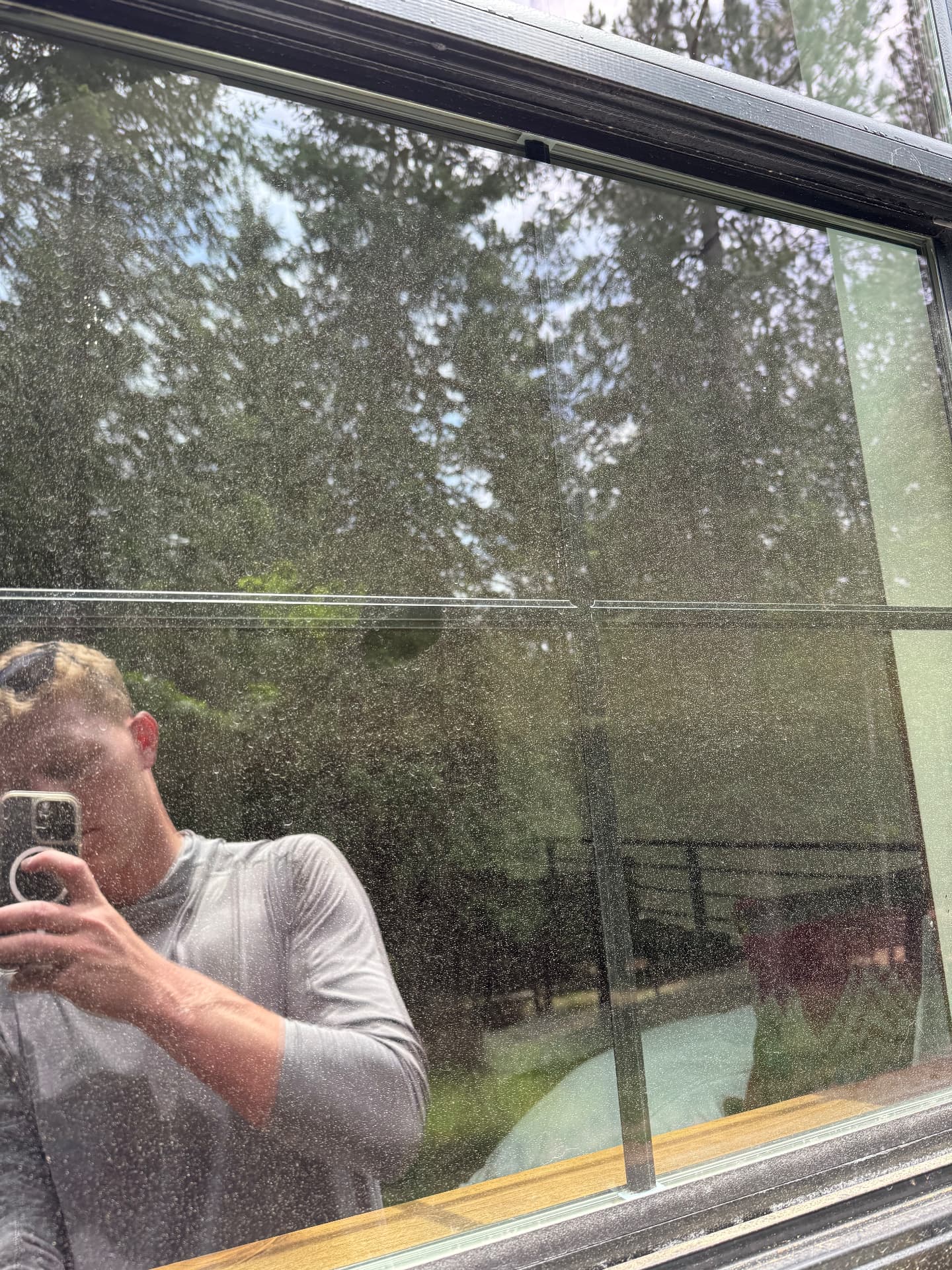 Window glass covered in dust and water spots before cleaning
